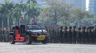 Kapolri Jendral Listyo Sigit Prabowo (kanan) mengecek pasukan saat Apel Gelar Pasukan Operasi Ketupat 2023 di Lapangan Monas, Jakarta Pusat, Senin (17/4/2023). [Suara.com/Alfian Winanto]