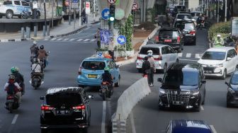 Kendaraan melintas di trotoar yang telah berubah fungsi menjadi jalan raya di Simpang Santa, Jakarta Selatan, Selasa (18/4/2023). [Suara.com/Alfian Winanto]