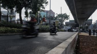 Kendaraan melintas di trotoar yang telah berubah fungsi menjadi jalan raya di Simpang Santa, Jakarta Selatan, Selasa (18/4/2023). [Suara.com/Alfian Winanto]