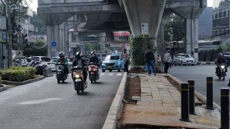 Kendaraan melintas di trotoar yang telah berubah fungsi menjadi jalan raya di Simpang Santa, Jakarta Selatan, Selasa (18/4/2023). [Suara.com/Alfian Winanto]