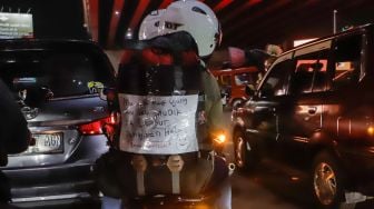 Pemudik yang menggunakan sepeda motor melintas di Jalan Raya Kalimalang, Jakarta Timur, Rabu (19/4/2023) malam. [Suara.com/Alfian Winanto]