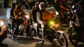 Pemudik yang menggunakan sepeda motor melintas di Jalan Raya Kalimalang, Jakarta Timur, Rabu (19/4/2023) malam. [Suara.com/Alfian Winanto]