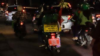 Pemudik yang menggunakan sepeda motor melintas di Jalan Raya Kalimalang, Jakarta Timur, Rabu (19/4/2023) malam. [Suara.com/Alfian Winanto]