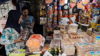 Pembeli memilih kue kaleng di salah satu toko kue kering di kawasan Ciracas, Jakarta Timur, Kamis (20/4/2023). [Suara.com/Alfian Winanto]