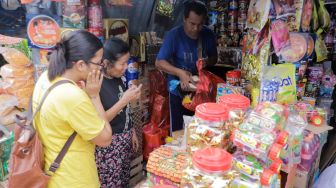 Pembeli memilih kue kaleng di salah satu toko kue kering di kawasan Ciracas, Jakarta Timur, Kamis (20/4/2023). [Suara.com/Alfian Winanto]