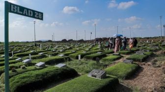 Warga melakukan ziarah kubur di Tempat Pemakaman Khusus Covid-19 TPU Rorotan, Jakarta Utara, Sabtu (22/4/2023). [Suara.com/Alfian Winanto]