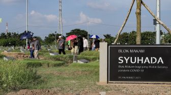 Warga melakukan ziarah kubur di Tempat Pemakaman Khusus Covid-19 TPU Rorotan, Jakarta Utara, Sabtu (22/4/2023). [Suara.com/Alfian Winanto]