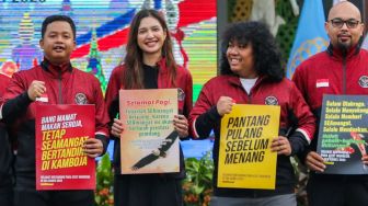 Komika Dustin Tiffani (kiri), artis Mikha Tambayong (kedua kiri), komika Marshel Widianto (kedua kanan), dan tokoh agama Yerry Pattinasarany (kanan) memegang poster dukungan untuk tim Indonesia usai upacara pengukuhan kontingen tim Indonesia untuk Sea Games ke-32 Vietnam tahun 2023 di lapangan Kementerian Pemuda dan Olahraga (Kemenpora), Jakarta, Selasa (2/5/2023). [Suara.com/Alfian Winanto]