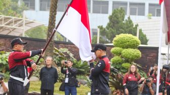 Menteri Pemuda dan Olahraga (Menpora) Ario Bimo Nandito Ariotedjo (kedua kanan) berjabat tangan dengan Karateka Ahmad Zigi Zaresta Yuda (kanan) disaksikan Ketua Umum Olimpiade Indonesia (KOI) Raja Sapta Oktohari (kedua kiri), dan CdM kontingen Indonesia Lexyndo Hakim (kiri) dalam upacara pengukuhan kontingen tim Indonesia untuk Sea Games ke-32 Kamboja tahun 2023 di lapangan Kementerian Pemuda dan Olahraga (Kemenpora), Jakarta, Selasa (2/5/2023). [Suara.com/Alfian Winanto]