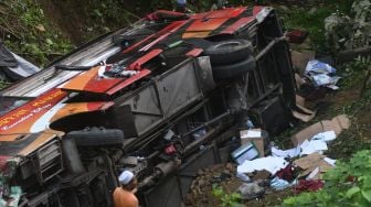 Seorang pria berada di sekitar bus pengangkut santri yang masuk ke jurang di kawasan Pegunungan Kebun Kopi di Parigi Moutong, Sulawesi Tengah, Kamis (4/5/2023). [ANTARA FOTO/Mohamad Hamzah].