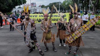 Sejumlah perwakilan masyarakat Suku Awyu Papua melakukan aksi di seberang Istana Merdeka, Jakarta Pusat, Kamis (11/5/2023). [Suara.com/Alfian Winanto]