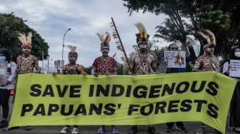 Sejumlah perwakilan masyarakat Suku Awyu Papua melakukan aksi di seberang Istana Merdeka, Jakarta Pusat, Kamis (11/5/2023). [Suara.com/Alfian Winanto]