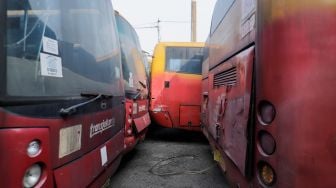 Deretan bus TransJakarta yang rusak dan tidak terawat terparkir di kawasan Terminal Terpadu Pulo Gebang, Jakarta Timur, Senin (15/5/2023). [Suara.com/Alfian Winanto]