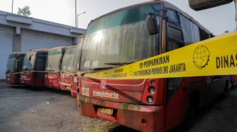 Deretan bus TransJakarta yang rusak dan tidak terawat terparkir di kawasan Terminal Terpadu Pulo Gebang, Jakarta Timur, Senin (15/5/2023). [Suara.com/Alfian Winanto]
