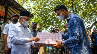 Wakil Presiden Ma'ruf Amin (kiri) memberikan laptop kepada perwakilan pengajar di RPTRA Amiterdam saat peresmian Kampung Bahari Nusantara (KBN) di Pulau Untung Jawa, Kepulauan Seribu, Jakarta, Senin (15/5/2023). [ANTARA FOTO/M Risyal Hidayat/tom]
