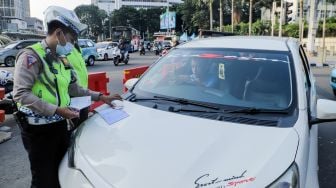 Petugas Kepolisian melakukan penindakan tilang manual terhadap pengemudi di kawasan Bundaran Hotel Indonesia, Jakarta, Selasa (16/5/2023). [Suara.com/Alfian Winanto]