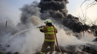 Petugas berusaha memadamkan api yang membakar pabrik plastik di Kalideres, Jakarta Barat, Jumat (19/5/2023). [ANTARA FOTO/Fauzan].