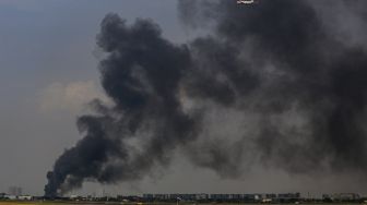 Asap membubung ke langit dari lokasi kebakaran pabrik plastik di Kalideres, Jakarta Barat, Jumat (19/5/2023).[ANTARA FOTO/Fauzan]