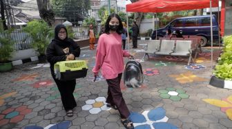 Warga membawa hewan peliharaan untuj divaksinasi rabies di Kelurahan Kebon Baru, Jakarta Selatan, Senin (22/5/2023). [Suara.com/Alfian Winanto]