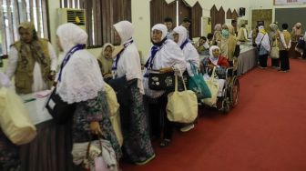 Jamaah calon haji embarkasi Jakarta mengantri untuk proses administrsi Asrama Haji Pondok Gede, Jakarta Timur, Selasa (23/5/2023). [Suara.com/Alfian Winanto]