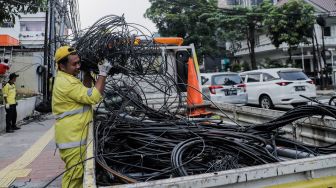 Petugas Dinas Bina Marga DKI Jakarta melakukan penataan kabel utilitas di sekitar Jalan Haji Agus Salim, Jakarta Pusat, Rabu (24/5/2023). [Suara.com/Alfian Winanto]