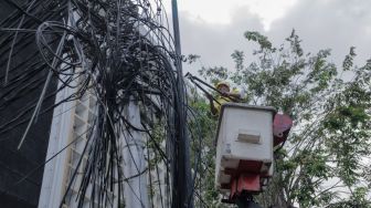 Petugas Dinas Bina Marga DKI Jakarta melakukan penataan kabel utilitas di sekitar Jalan Haji Agus Salim, Jakarta Pusat, Rabu (24/5/2023). [Suara.com/Alfian Winanto]