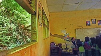 Guru dan sejumlah murid beraktivitas di ruang kelas yang rusak di SD Negeri Tanjung Ilir, Sayar, Kota Serang, Banten, Sabtu (27/5/2023). [ANTARA FOTO/Asep Fathulrahman].