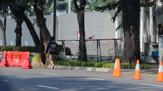 Sejumlah pejalan kaki melintasi trotoar di depan kantor Kedutaan Besar Amerika Serikat (Kedubes AS) di Jalan Merdeka Selatan, Jakarta, Rabu (7/6/2023). [Suara.com/Alfian Winanto]