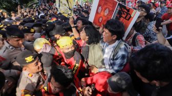 Sejumlah buruh dan aktivis yang menggelar aksi unjuk rasa untuk mendukung Haris Azhar dan Fatia terlibat bentrokan dengan pihak kepolisian yang berjaga di depan Pengadilan Negeri Jakarta Timur, Kamis (8/6/2023). [Suara.com/Alfian Winanto]