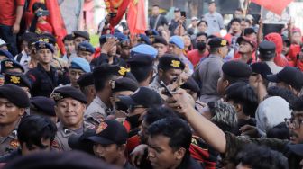 Sejumlah buruh dan aktivis yang menggelar aksi unjuk rasa untuk mendukung Haris Azhar dan Fatia terlibat bentrokan dengan pihak kepolisian yang berjaga di depan Pengadilan Negeri Jakarta Timur, Kamis (8/6/2023). [Suara.com/Alfian Winanto]