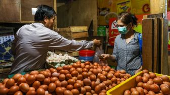 Pedagang melayani pembeli telur ayam di Pasar Tebet, Jakarta Selatan, Jumat (9/6/2023). [Suara.com/Alfian Winanto]