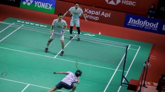 Pebulu tangkis ganda putra Indonesia Mohammad Ahsan (atas kiri) dan Hendra Setiawan (atas kanan) saat bertanding dengan ganda putra Thailand Supak Jomkoh dan Kittinupong Kedren dalam babak pertama (32 besar) turnamen Indonesia Open 2023 di Istora Senayan, Jakarta, Rabu (14/6/2023). [Suara.com/Alfian Winanto]
