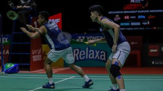 Pebulu tangkis ganda putra Indonesia Pramudya Kusumawardana (kiri) dan Yeremia Rambitan (kanan) saat bertanding dengan ganda putra Malaysia Aaron Chia  dan Soh Wooi Yik dalam babak Semifinal  turnamen Indonesia Open 2023 di Istora Senayan, Jakarta, Sabtu (17/6/2023). [Suara.com/Alfian Winanto]