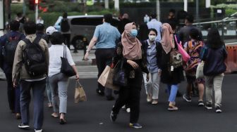 Pejalan kaki memakai masker saat melintas di Kawasan Bundaran HI, Jakarta, Rabu (21/6/2023). [Suara.com/Alfian Winanto]