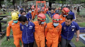 Tim gabungan dari Basarnas dan Damkar membawa jenazah Fajri, pria obesitas 300 kg, menggunakan forklit untuk dimakamkan di Taman Pemakaman Umum (TPU) Menteng Pulo, Jakarta, Kamis (22/6/2023). [Suara.com/Alfian Winanto]