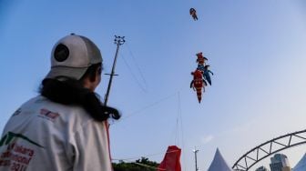 Peserta menerbangkan layang-layang saat Festival Layang-layang Jakarta di Pantai Lagoon Ancol, Kamis (22/6/2023). [Suara.com/Alfian Winanto]