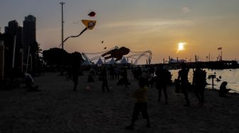 Peserta menerbangkan layang-layang saat Festival Layang-layang Jakarta di Pantai Lagoon Ancol, Kamis (22/6/2023). [Suara.com/Alfian Winanto]