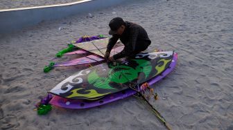 Peserta menyiapkan layang-layang saat Festival Layang-layang Jakarta di Pantai Lagoon Ancol, Kamis (22/6/2023). [Suara.com/Alfian Winanto]