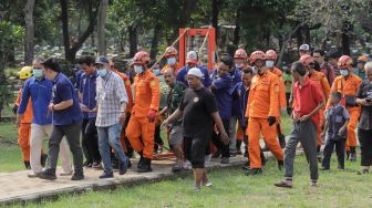 Tim gabungan dari Basarnas dan Damkar membawa jenazah Fajri, pria obesitas 300 kg, menggunakan forklit untuk dimakamkan di Taman Pemakaman Umum (TPU) Menteng Pulo, Jakarta, Kamis (22/6/2023). [Suara.com/Alfian Winanto]