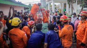 Tim gabungan dari Basarnas dan Damkar membawa jenazah Fajri, pria obesitas 300 kg, menggunakan forklit untuk dimakamkan di Taman Pemakaman Umum (TPU) Menteng Pulo, Jakarta, Kamis (22/6/2023). [Suara.com/Alfian Winanto]