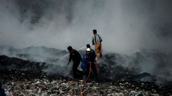 Petugas berusaha memadamkan api saat kebakaran lahan di Tempat Pembuangan Akhir (TPA) Desa Dermasuci, Kabupaten Tegal, Jawa Tengah, Selasa (27/6/2023). [ANTARA FOTO/Oky Lukmansyah].