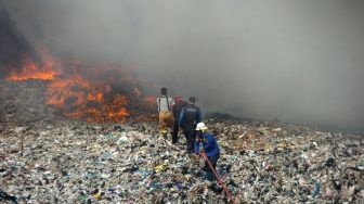 Petugas berusaha memadamkan api saat kebakaran lahan di Tempat Pembuangan Akhir (TPA) Desa Dermasuci, Kabupaten Tegal, Jawa Tengah, Selasa (27/6/2023). [ANTARA FOTO/Oky Lukmansyah]