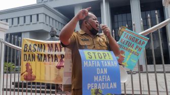 Kepala Desa Tiberias, Abner Patras saat menggelar aksi demo tunggal di depan Gedung Mahkamah Agung RI, Jakarta Pusat, Rabu (5/7/2023). [Suara.com/Alfian Winanto]