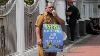 Kepala Desa Tiberias, Abner Patras saat menggelar aksi demo tunggal di depan Gedung Mahkamah Agung RI, Jakarta Pusat, Rabu (5/7/2023). [Suara.com/Alfian Winanto]