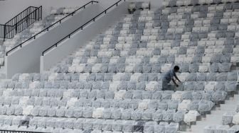 Petugas membersihkan tribun penonton di Indonesia Arena, Senayan, Jakarta, Selasa (11/7/2023). [Suara.com/Alfian Winanto]