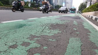 Sejumlah kendaraan melintas di kawasan Sudirman, Jakarta, Jumat (14/7/2023). [Suara.com/Alfian Winanto]