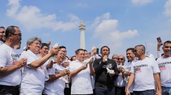 Ketua Umum terpilih Partai Kebangkitan Nusantara, Anas Urbaningrum (tengah) melepas burung merpati secara sombolik usai memberikan pidato politik di Kawasan Monas, Jakarta, Sabtu (15/7/2023). [Suara.com/Alfian Winanto]