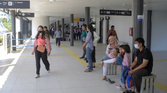 Calon penumpang menunggu kedatangan bus Transjakarta di Halte Transjakarta Kampung Melayu, Jakarta, Rabu (19/7/2023). [Suara.com/Alfian Winanto]