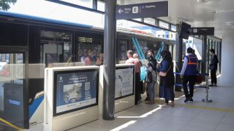 Calon penumpang menunggu kedatangan bus Transjakarta di Halte Transjakarta Kampung Melayu, Jakarta, Rabu (19/7/2023). [Suara.com/Alfian Winanto]