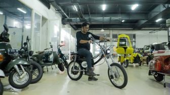 Pekerja mencoba vespa klasik yang sudah dikonversi menjadi vespa listrik di bengkel Elders Garage, Gedung Smesco Jakarta, Kamis (28/7/2022). [Suara.com/Alfian Winanto]